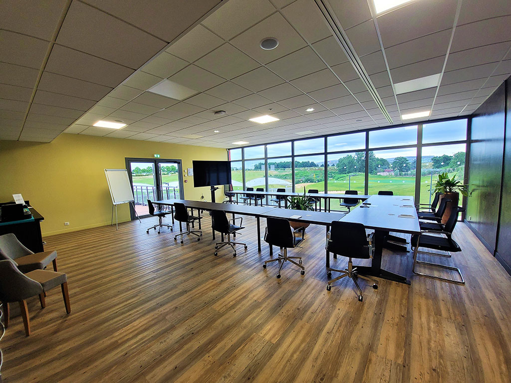 photo d'une salle de réunion du Golf de Roissy, le confort d'une salle équipée avec vue sur le golf et la verdure